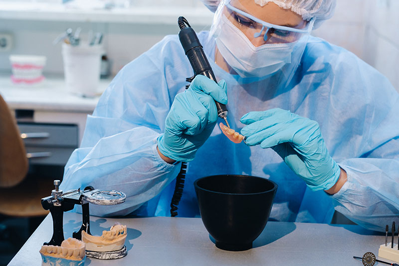 Dentist preparing custom dentures using dental molds for a patient in Brookfield, CT.